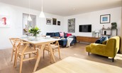 7 The Bay, Coldingham - open-plan living space with plush colourful sofas and dining space for four