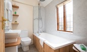 The Craftsman's Cottage - family bathroom featuring a bath with shower over