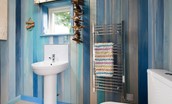 Berrington Beach Hut - shower room with basin and WC and a distinctly beach vibe