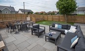 Driftwood Bamburgh - large sheltered patio with outdoor sofa and dining table with eight chairs