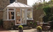 The Old Paper Mill - conservatory leading out to the patio garden with outdoor dining table and chairs