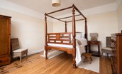 Dipper Cottage - bedroom one with king size, four-poster bed, chest of drawers and side tables
